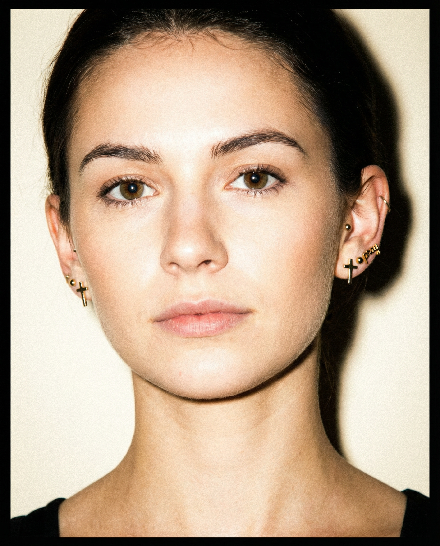 Woman wearing gold Christian cross stud earrings