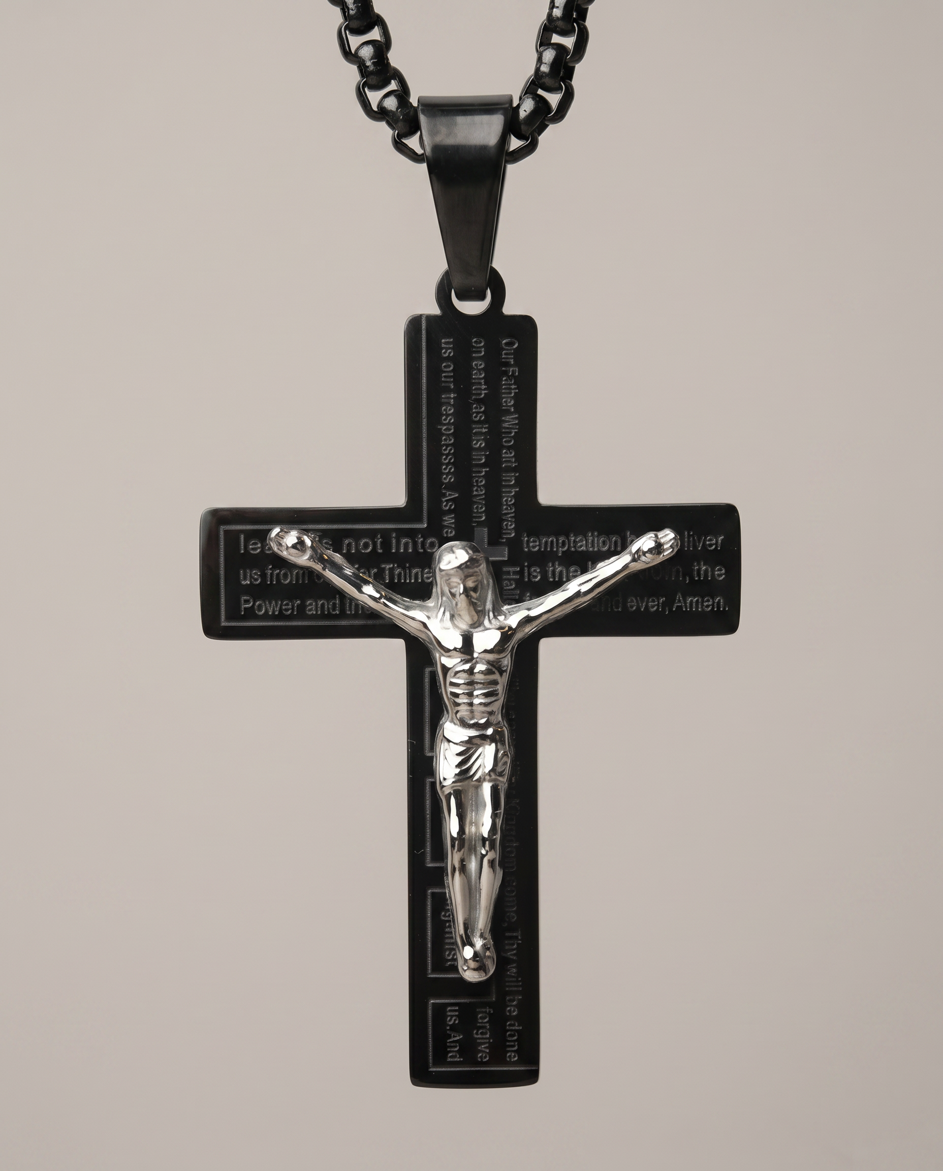 Close-up of crucifix pendant showing engraved Lord's Prayer detail
