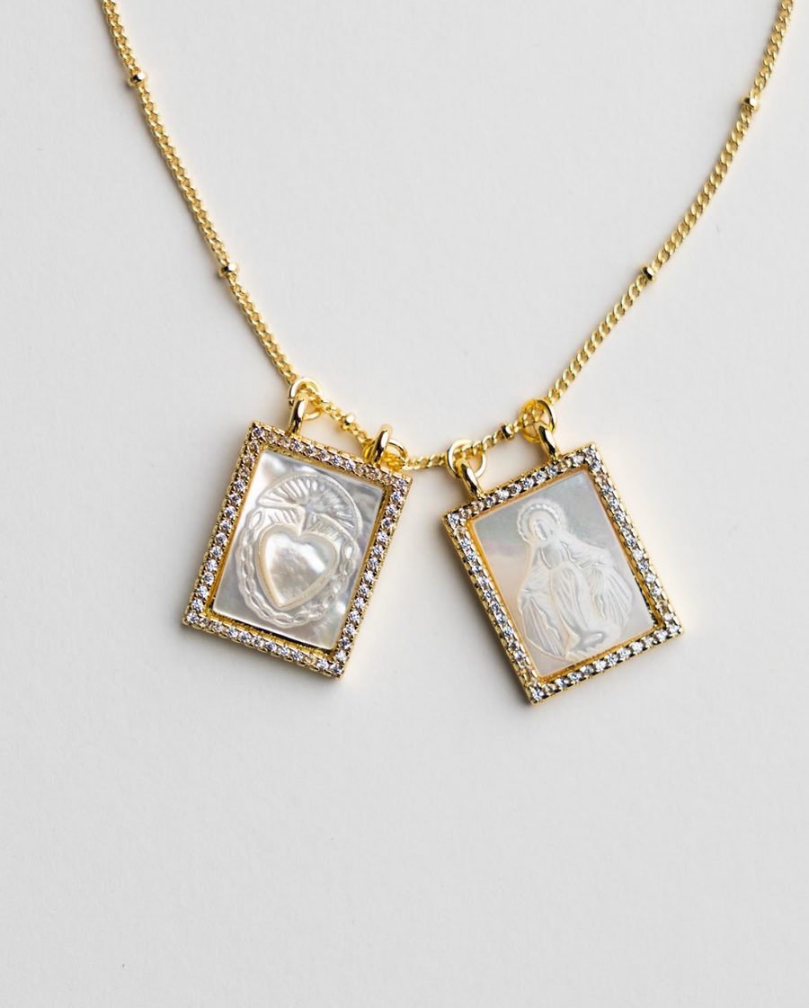 Close-up of Christian scapular pendant charms with religious imagery