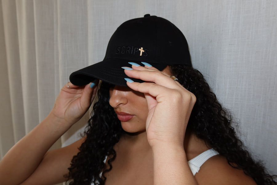 Woman wearing black "I Believe" Christian baseball cap