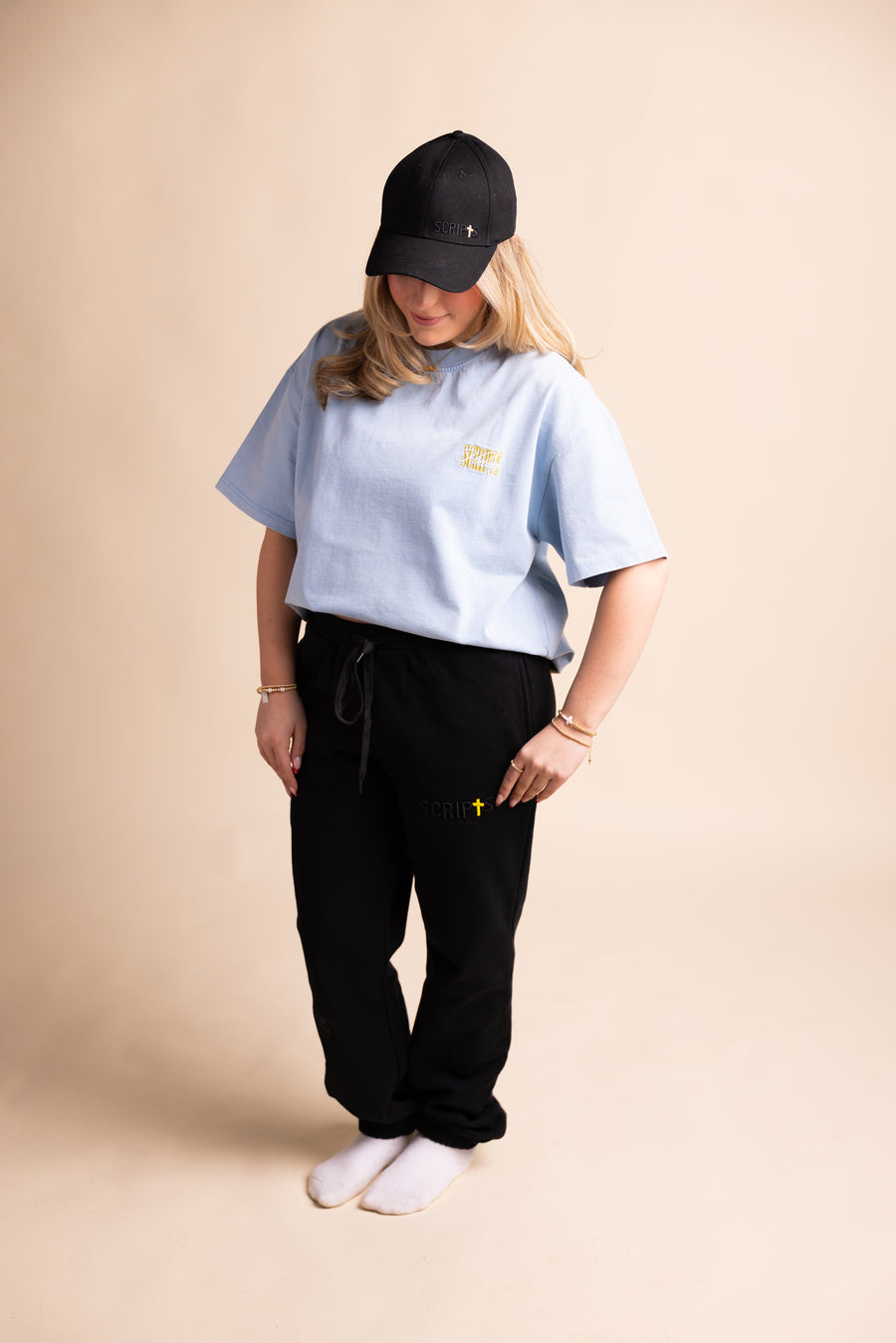 Woman wearing black cap and light blue "Respond Like Jesus" Christian tee - full body