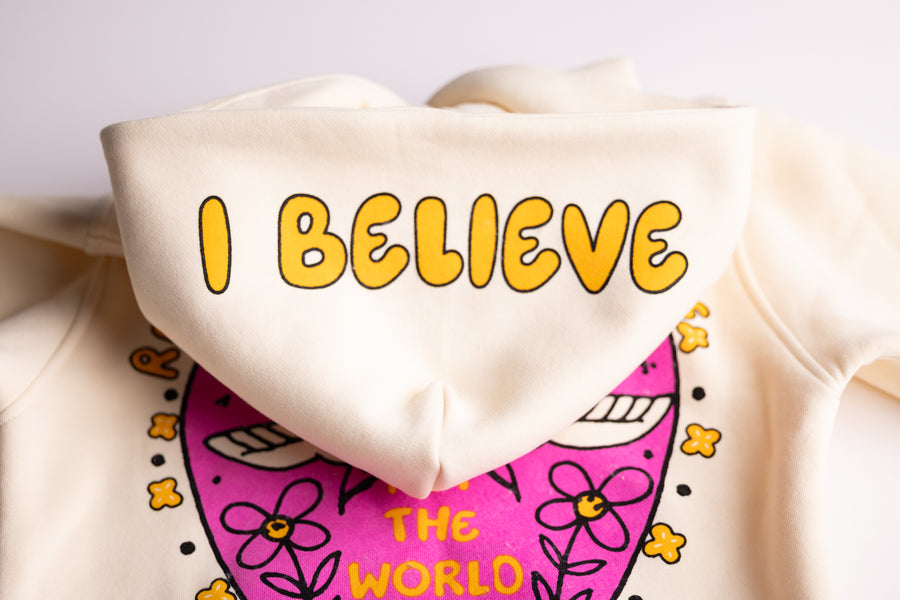 Christian youth hoodie with pink "I Believe" heart graphic on cream fleece